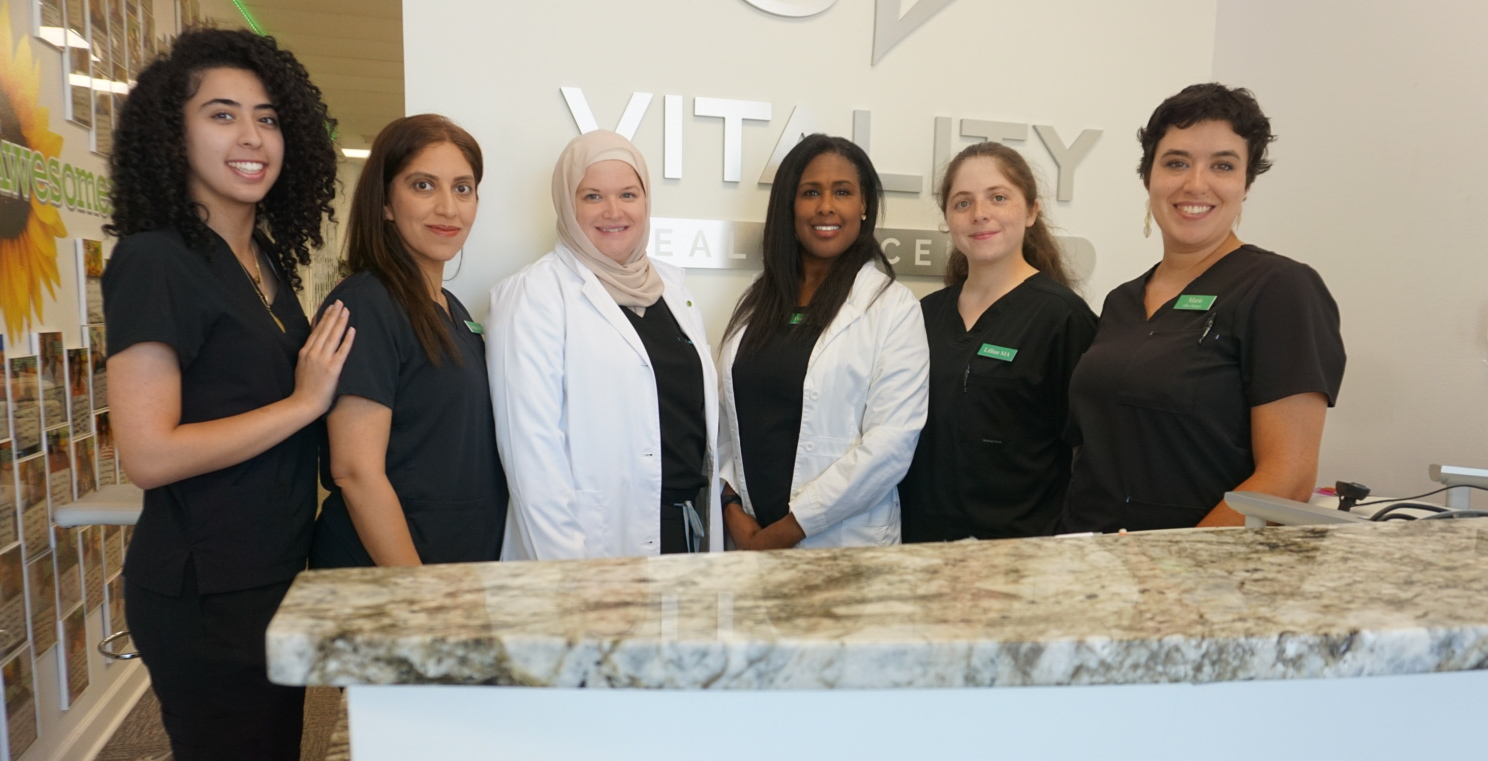 Vitality team members together in the clinic reception area.